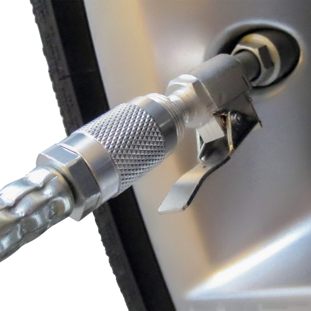 A close-up of the Prestacycle Prestaflator PRO Bicycle Tire Inflator nozzle attached to a Presta valve, showing its textured grip and lever for a secure fit; compatible with both Presta and Schrader valves for easy tire inflation.