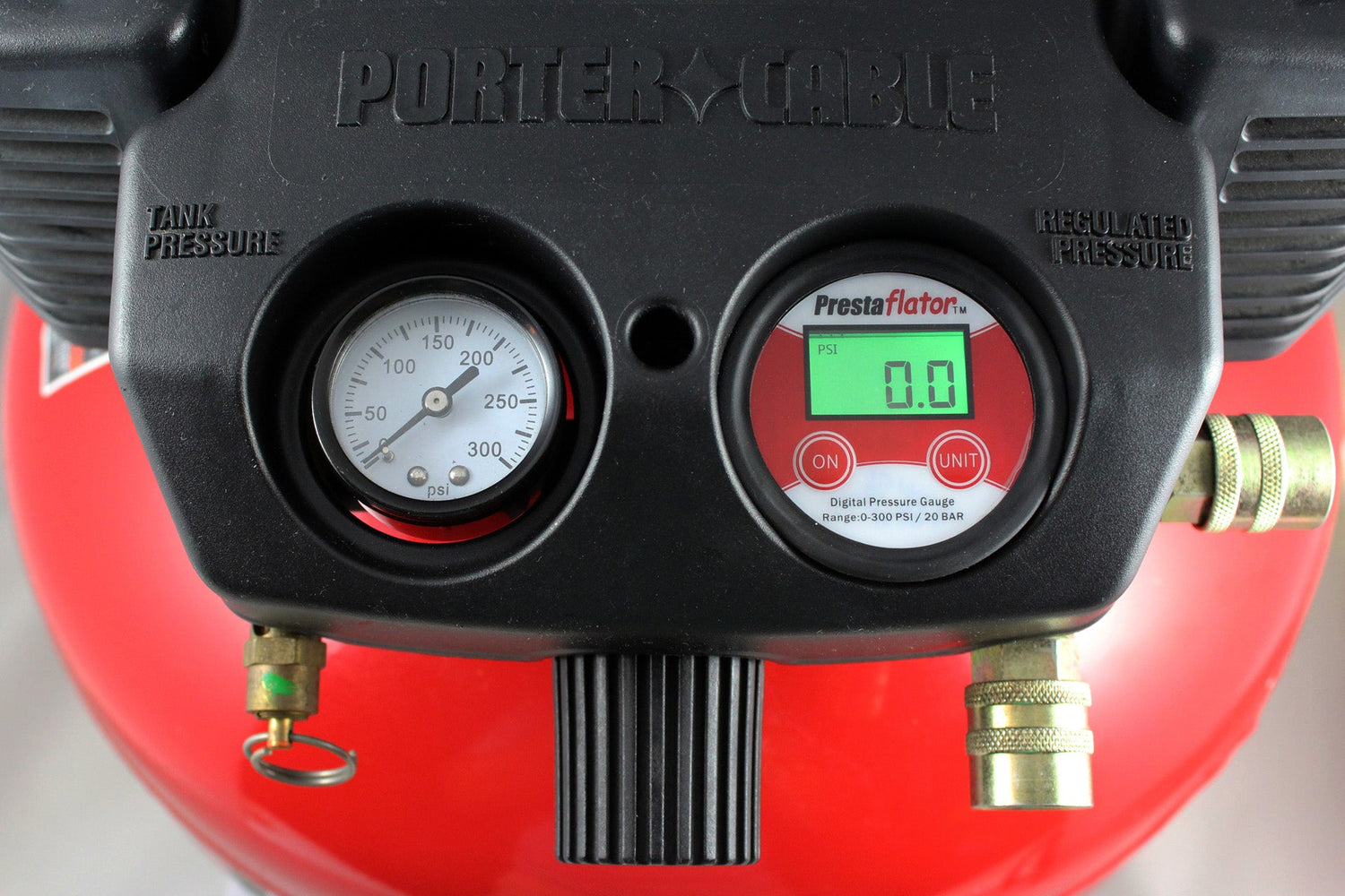 Close-up of a Prestacycle Prestaflator Digital Gauge for Air Compressors &amp; Floor Pumps with an analog tank pressure gauge, both showing clear dials and connectors, set against a vivid red background.