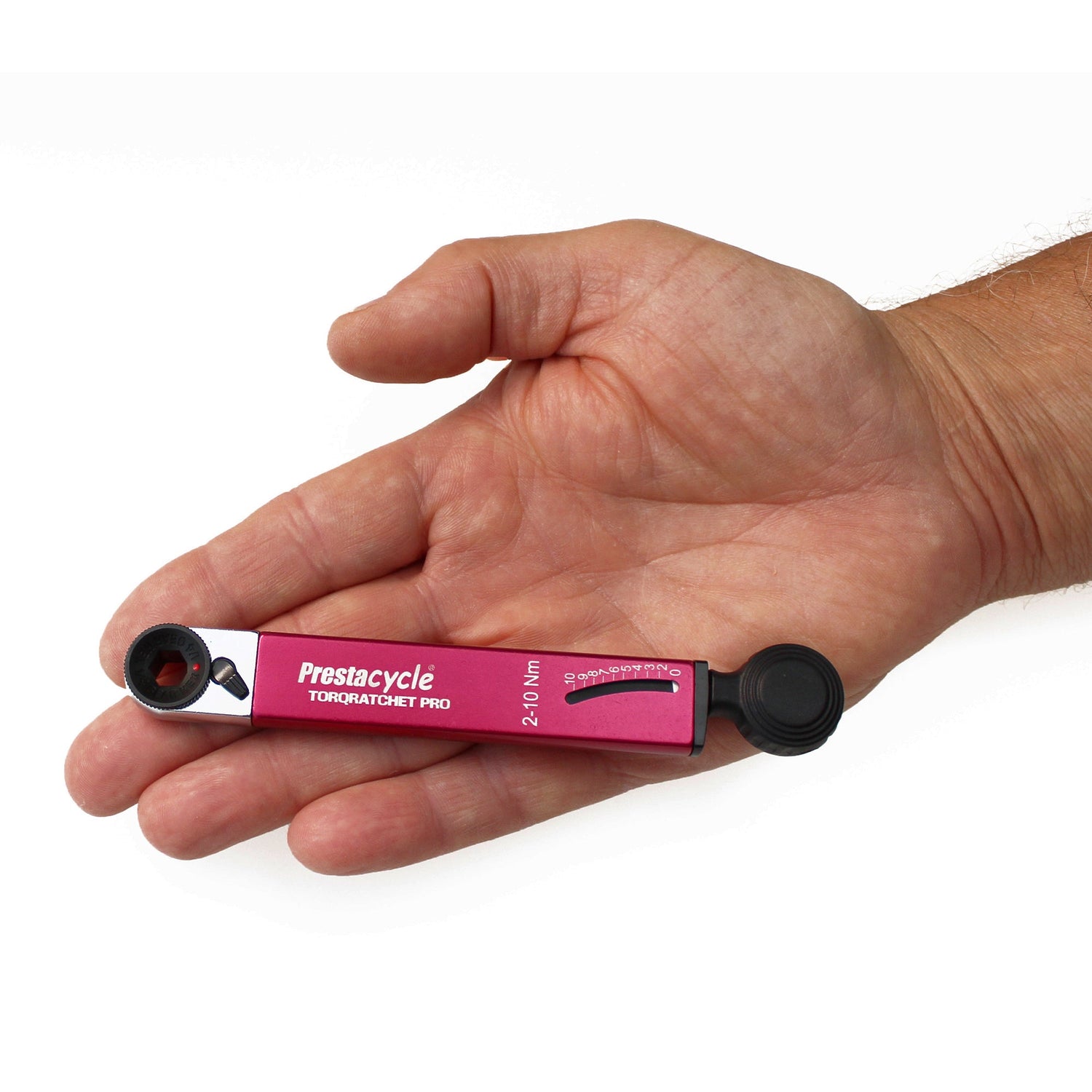A hand holds the compact Prestacycle TorqRatchet PRO Wallet, a Pro multi-tool and 2–10Nm torque ratchet, showing its pink finish and clearly marked torque settings.