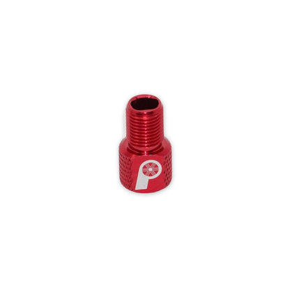 The Prestacycle Prestadapter TUBELESS is a small, red, lightweight alloy Schrader-to-Presta valve adapter and core remover with threading and a white P-and-wheel logo, shown isolated on a white background.